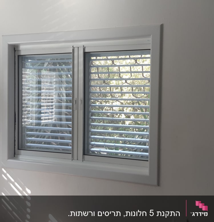 חלון אלומיניום עם תריסים פתוחים למחצה